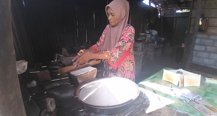 Jahra yang sedang memasukan tepung kasbi ke dalam porna, di rumahnya, Desa Lola, Kecamatan Oba Tengah, Tidore Kepulauan, Sabtu 18 Desember 2021. (Apriyanto Latukau/kieraha.com)