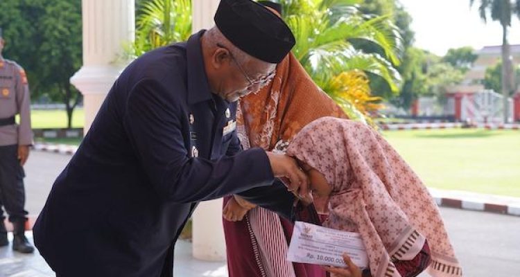 Wali Kota Tidore Capt H Ali Ibrahim saat menyerahkan penghargaan berupa bonus uang senilai Rp 10 juta kepada Juara 3 MTQ tingkat Internasional Izzah Qurrataain Mubarak. (Dok humas/kieraha.com)